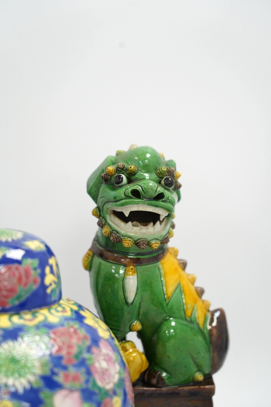 A pair of Chinese lion dogs and a floral enamelled jar and cover, largest 26cm high. Condition - good